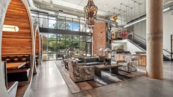 A modern living room with a curved wooden wall and a staircase.